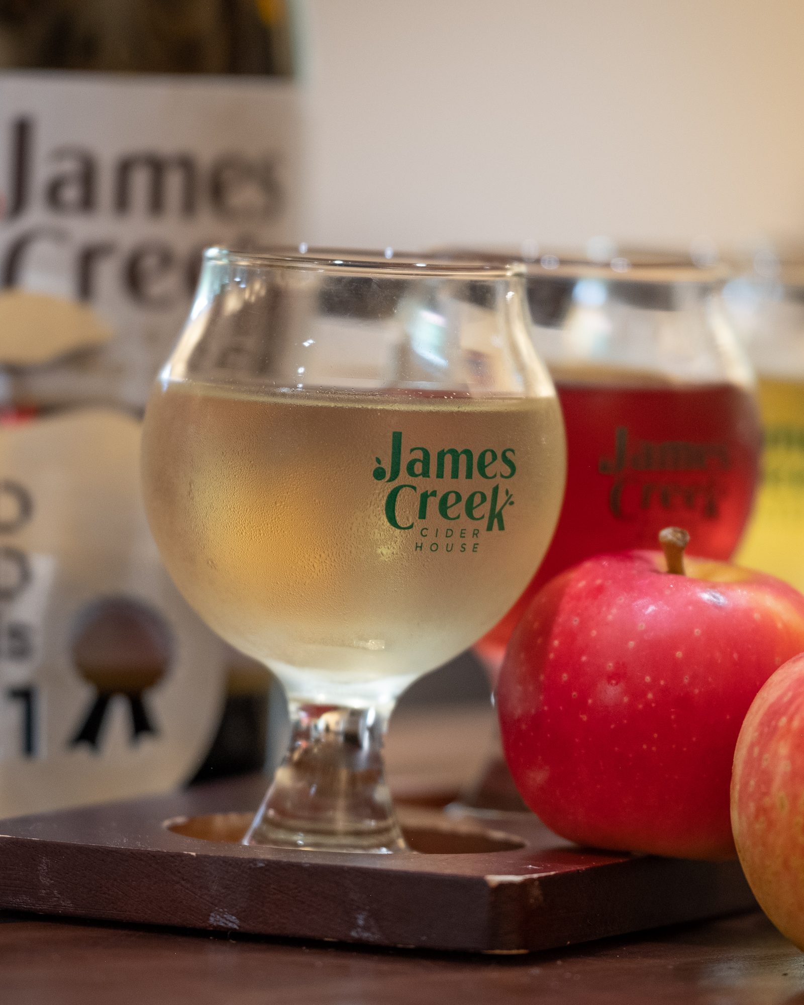 Flight of cider glasses arranged with apples and an award plaque