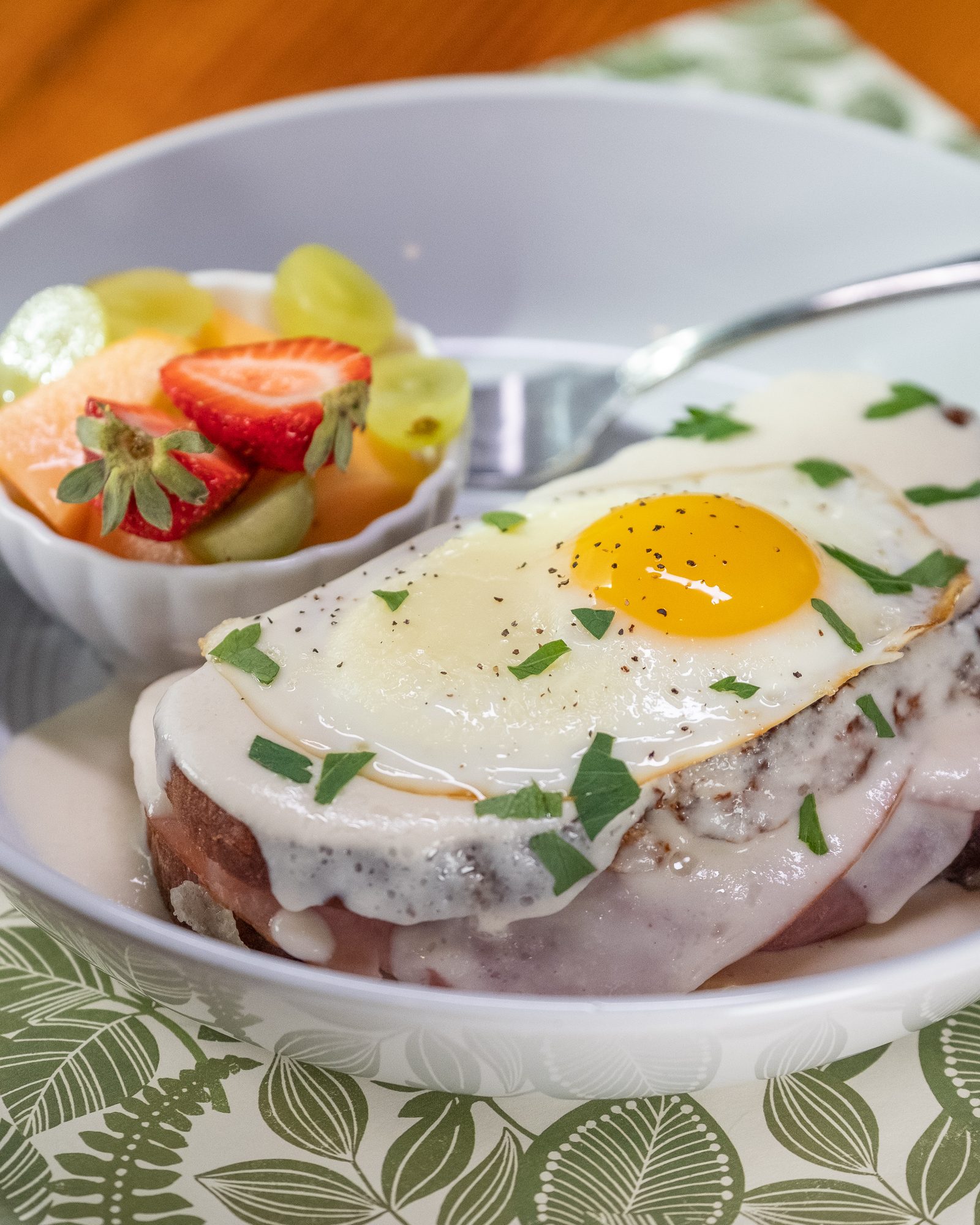 Brunch plate topped with a fried egg and served with fresh fruit