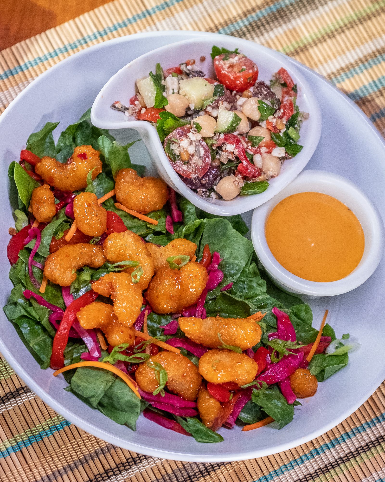 Colorful composed bowls of vegetables and grains on a patterned table runner