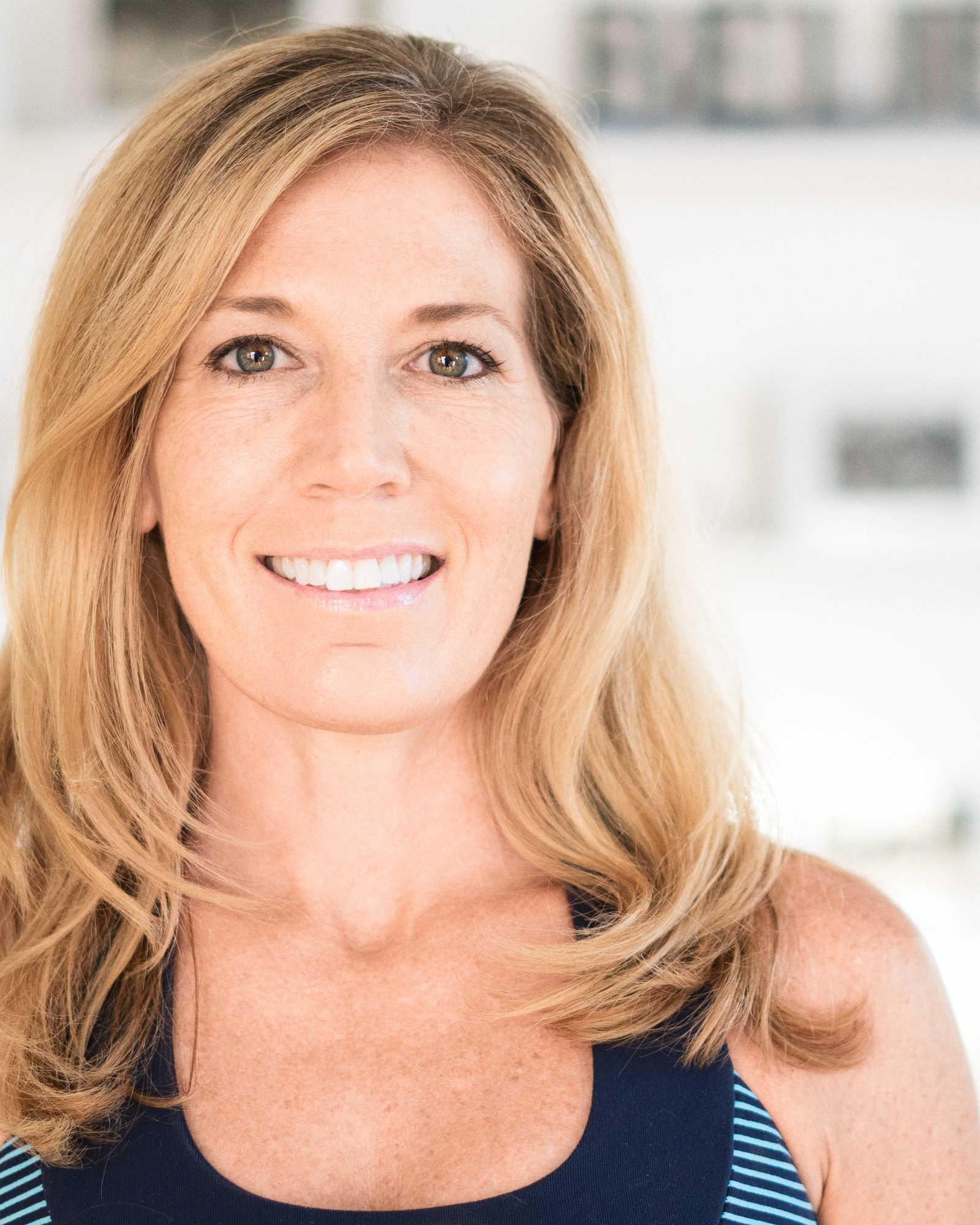 Smiling blonde woman photographed in a bright fitness studio