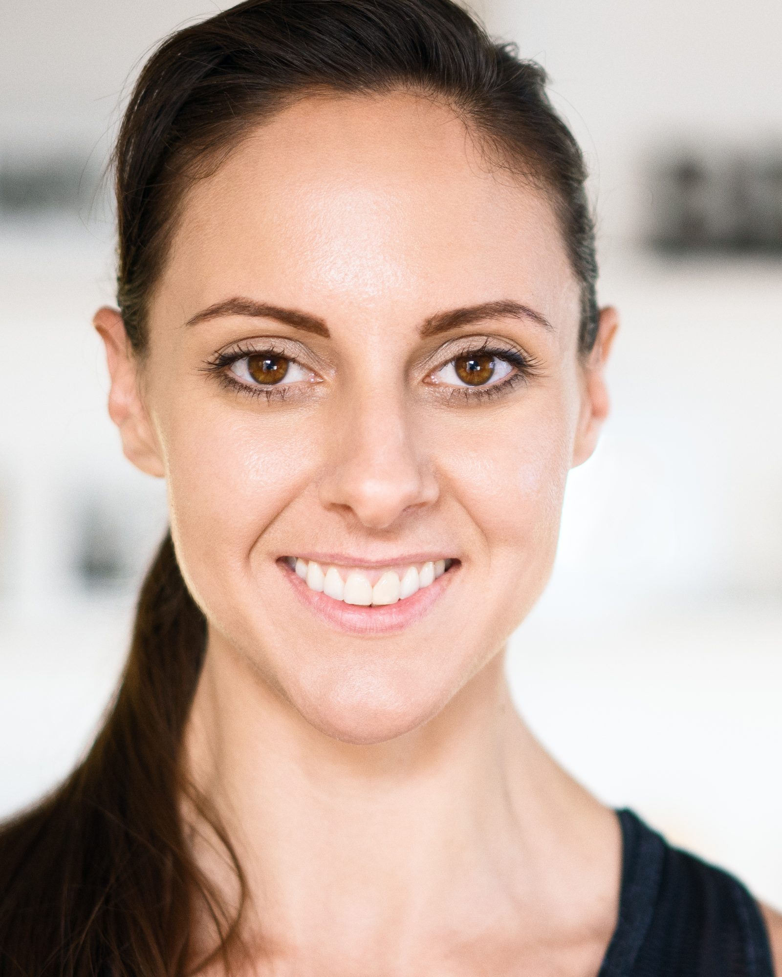 Smiling brunette woman photographed in a bright fitness studio