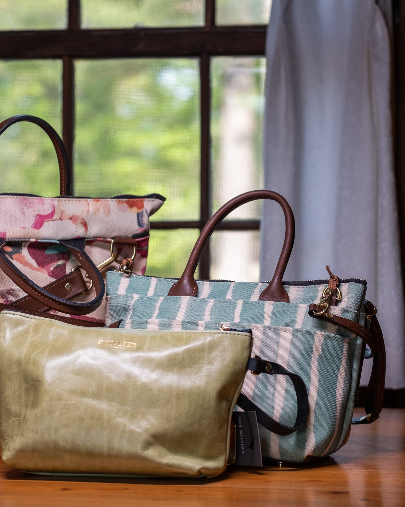 Coordinated collection of patterned handbags arranged in a warm interior