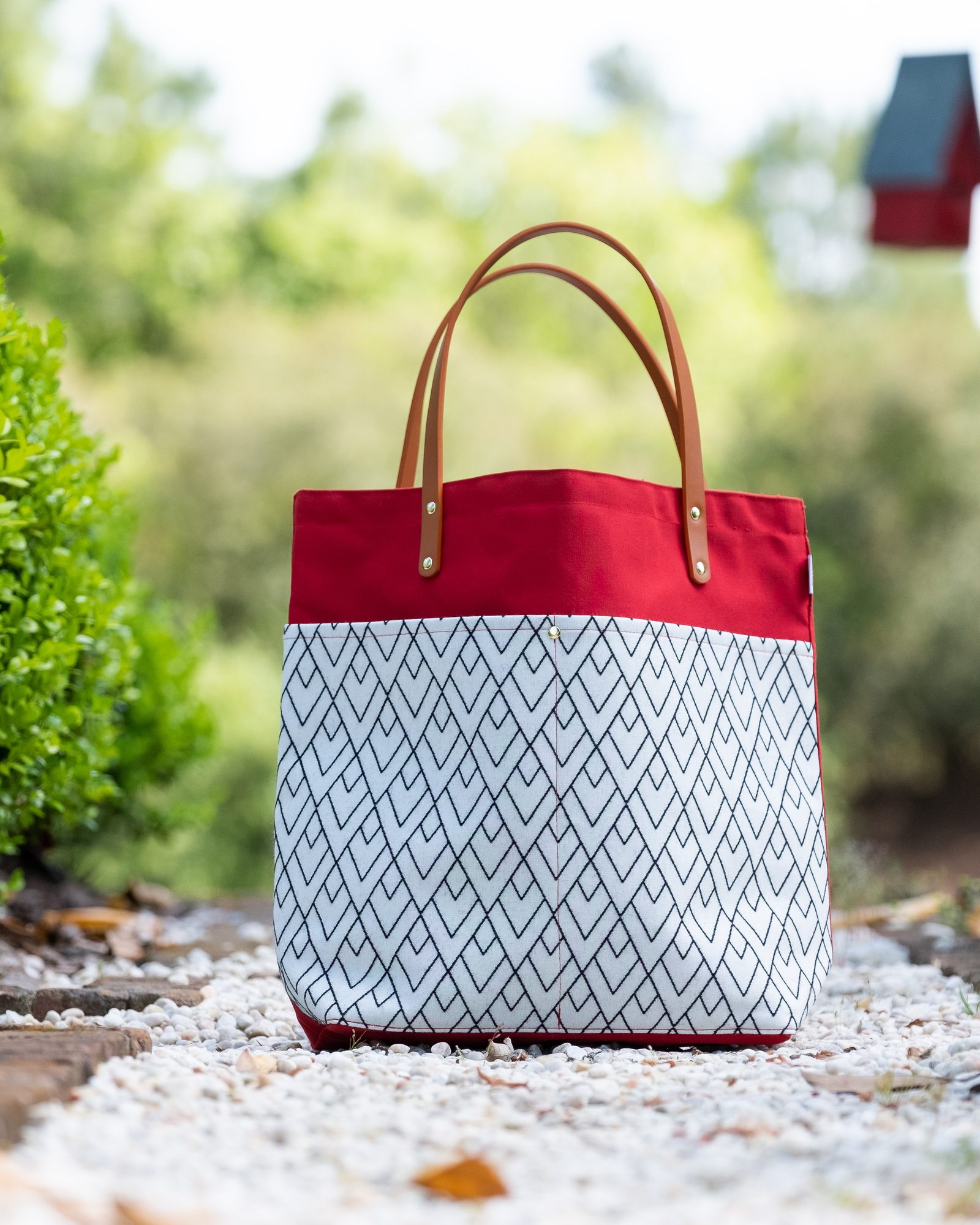Patterned tote bag photographed outdoors against green foliage