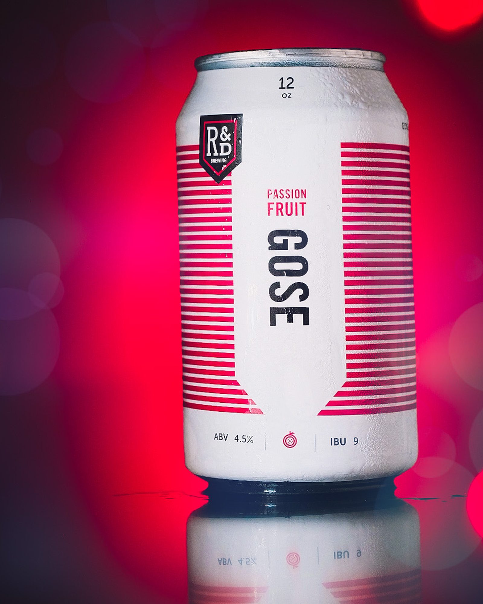 Single beverage can photographed with vivid red backlight and soft bokeh